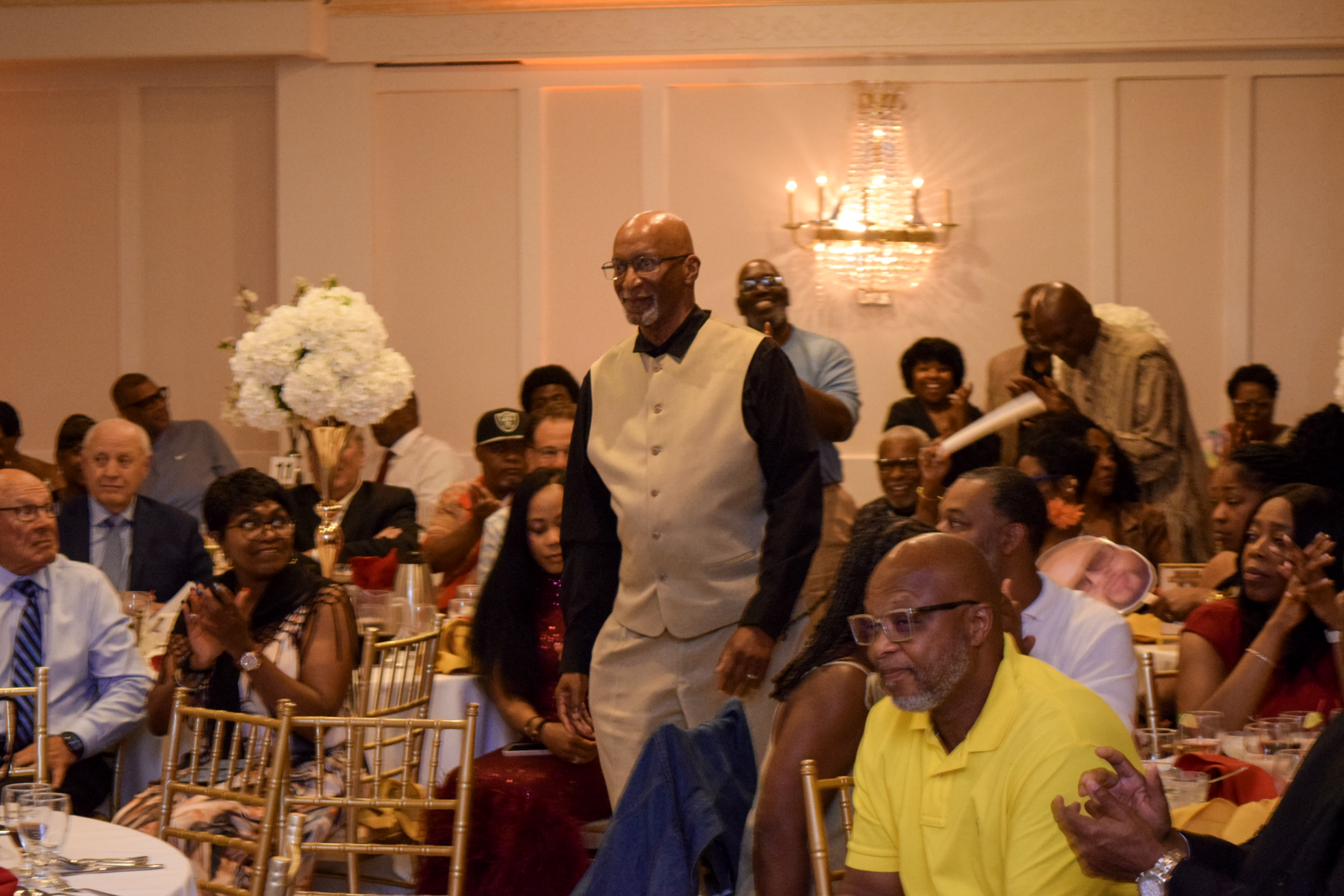 A member of the 1970 Thomas Jefferson High School Football Team makes his way to the podium.