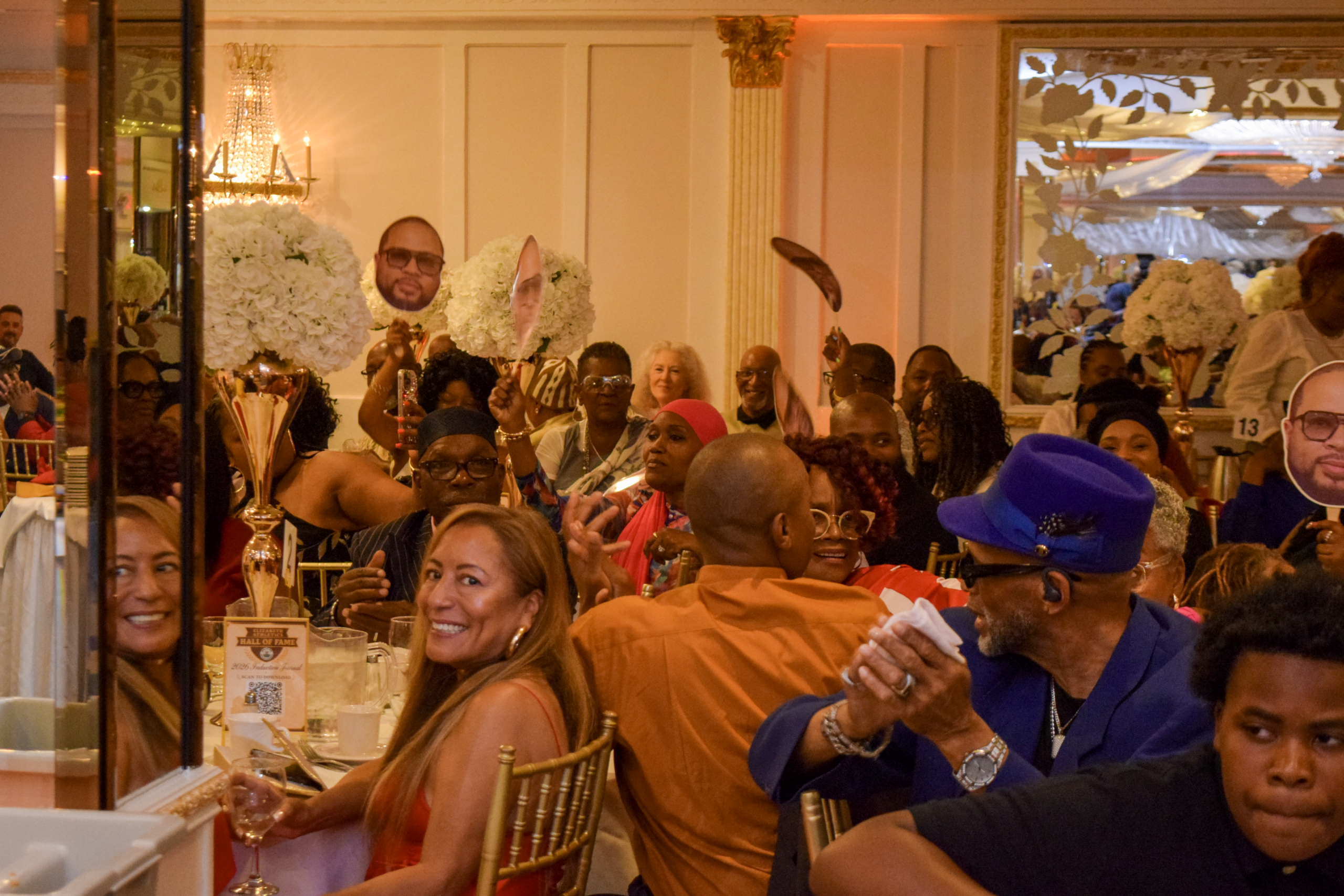 Guests celebrate the evening, with a sign supporting inductee Asad Abdul-Khaliq visible in the background.